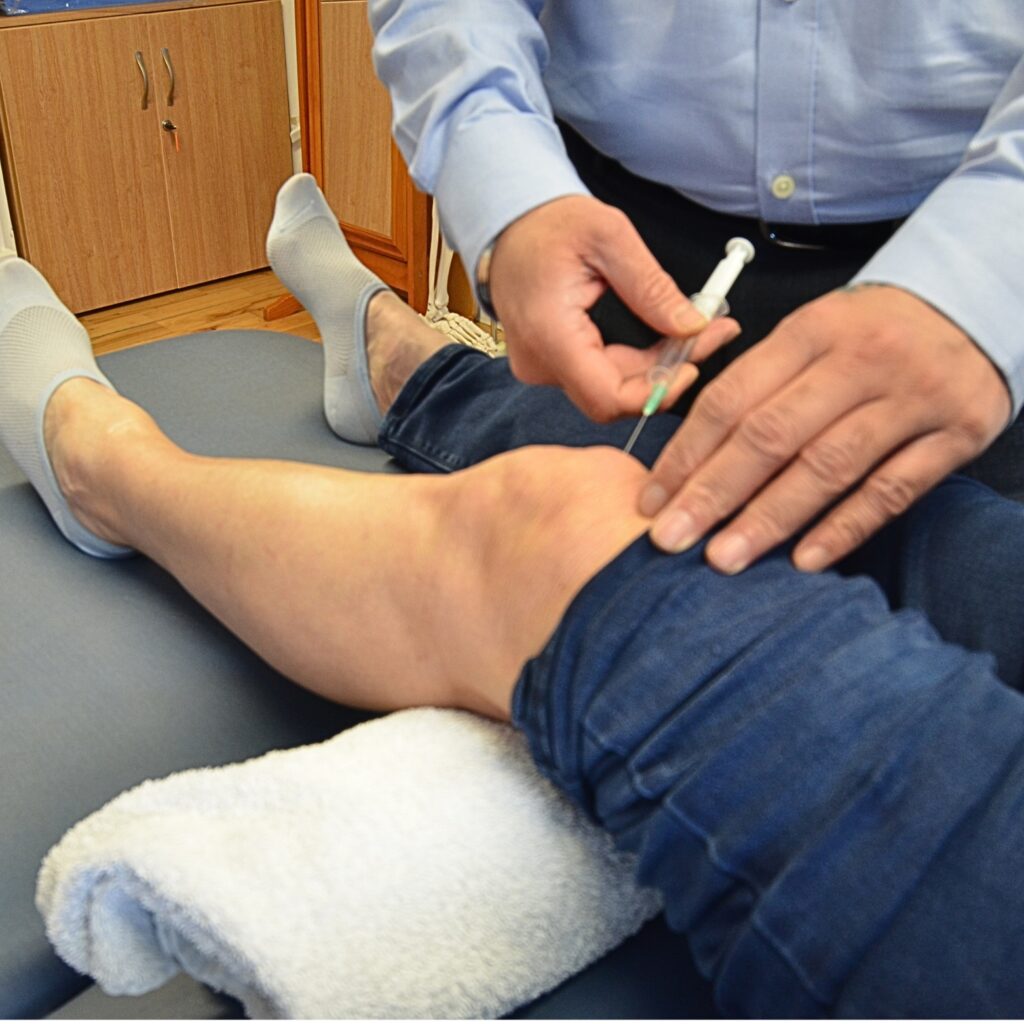 Physiotherapist giving a joint injection to a patient to relieve joint pain.